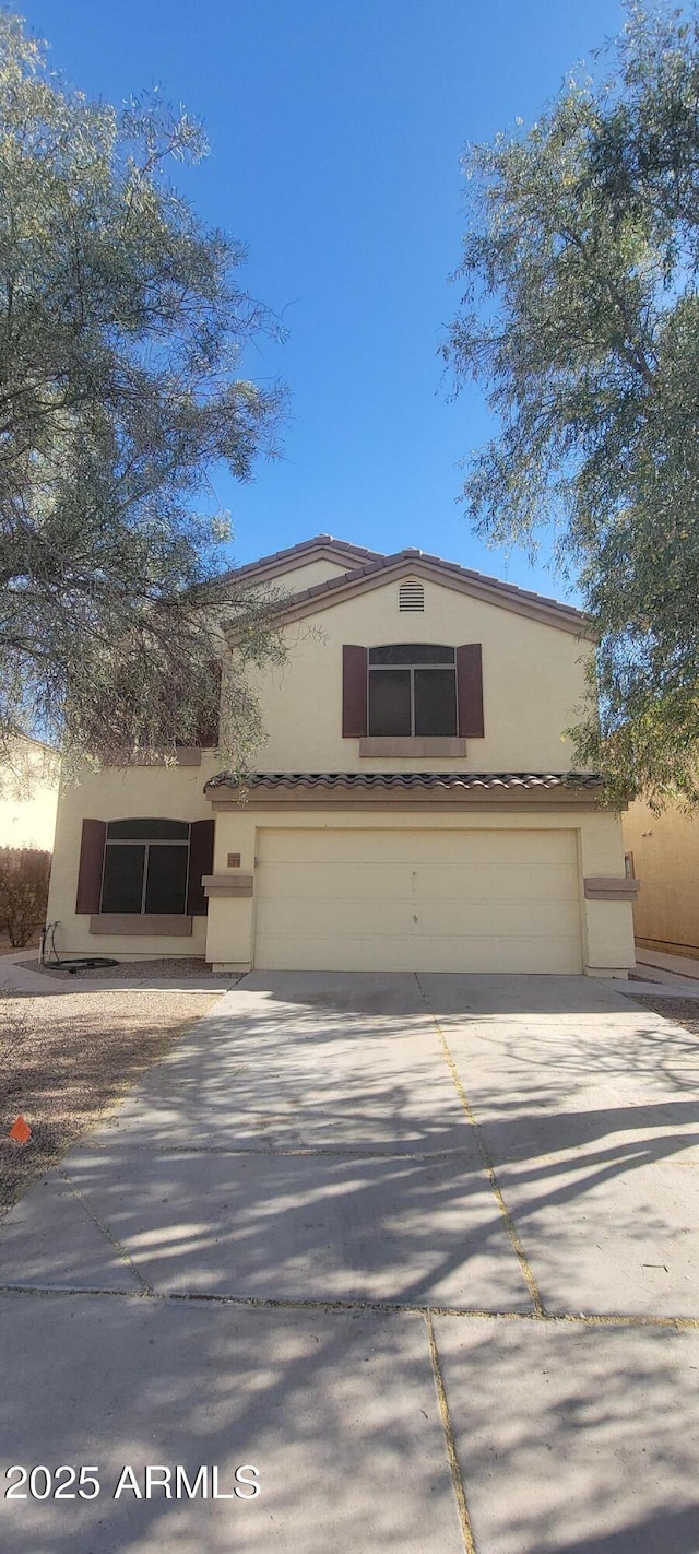 view of front facade featuring a garage, driveway, and stucco siding