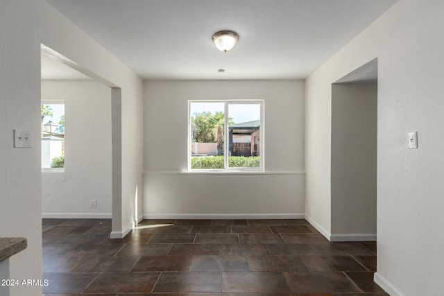 spare room featuring dark tile flooring