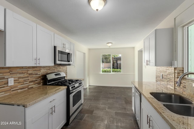 kitchen featuring white cabinets, backsplash, and stainless steel appliances