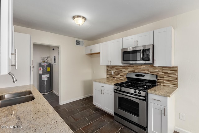 kitchen featuring white cabinetry, appliances with stainless steel finishes, sink, light stone counters, and tasteful backsplash