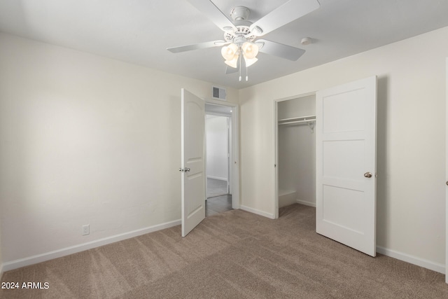 unfurnished bedroom featuring ceiling fan, a closet, and light carpet