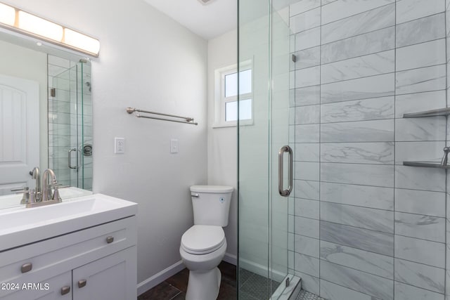 bathroom with toilet, a shower with door, tile floors, and vanity