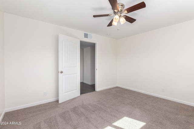 unfurnished bedroom with dark colored carpet and ceiling fan