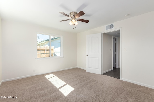 unfurnished room featuring dark carpet and ceiling fan