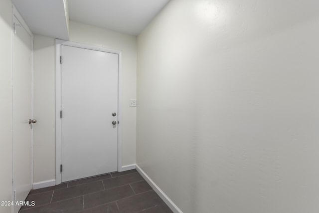 entryway with dark tile flooring