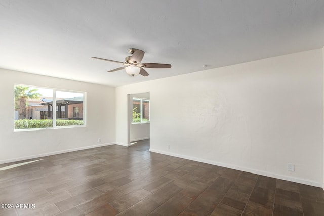 empty room with dark hardwood / wood-style floors and ceiling fan