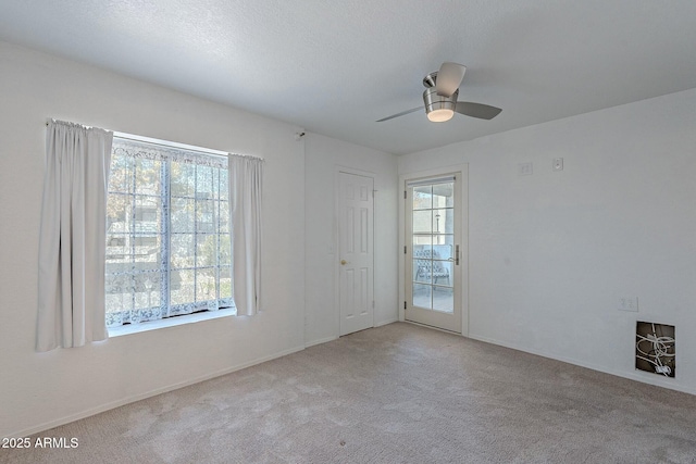 empty room featuring ceiling fan and light carpet