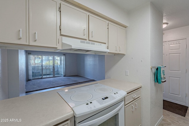 kitchen with white cabinets, electric range, and a textured ceiling