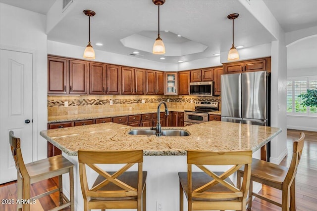 4402 E Barwick Dr, Cave Creek, AZ 85331 - kitchen featuring appliances with stainless steel finishes, brown cabinets, wood finished floors, tasteful backsplash, and recessed lighting