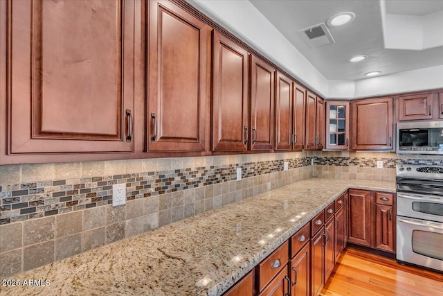 4402 E Barwick Dr, Cave Creek, AZ 85331 - kitchen featuring stainless steel appliances, light stone counters, light wood finished floors, tasteful backsplash, and recessed lighting