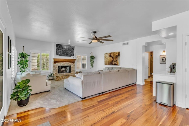 4402 E Barwick Dr, Cave Creek, AZ 85331 - living room with light wood-type flooring, ceiling fan, and a stone fireplace
