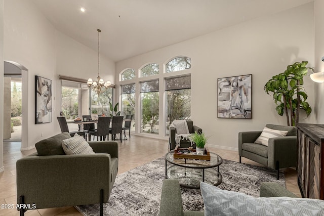 tiled living room with a chandelier and high vaulted ceiling