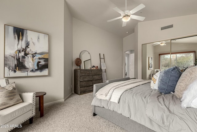 carpeted bedroom with ceiling fan, a closet, and vaulted ceiling