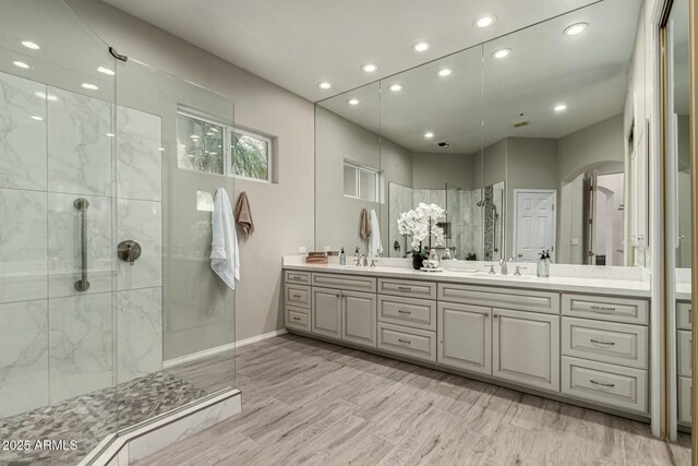 bathroom with tiled shower and vanity