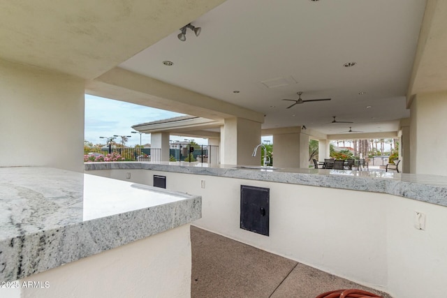 view of patio featuring exterior bar and ceiling fan