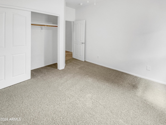 unfurnished bedroom with carpet flooring and a closet