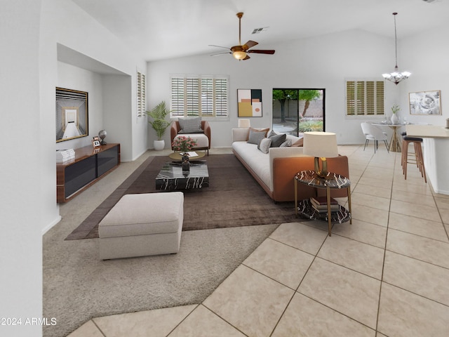 living room featuring ceiling fan with notable chandelier, light tile patterned floors, and vaulted ceiling