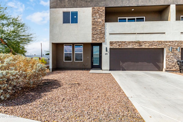 2000 N 36th St Unit 29, Phoenix, AZ 85008 - view of front facade featuring an attached garage, concrete driveway, stucco siding, and stone siding