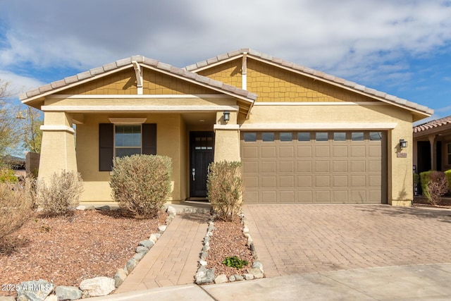 view of front of home with a garage, decorative driveway, and stucco siding