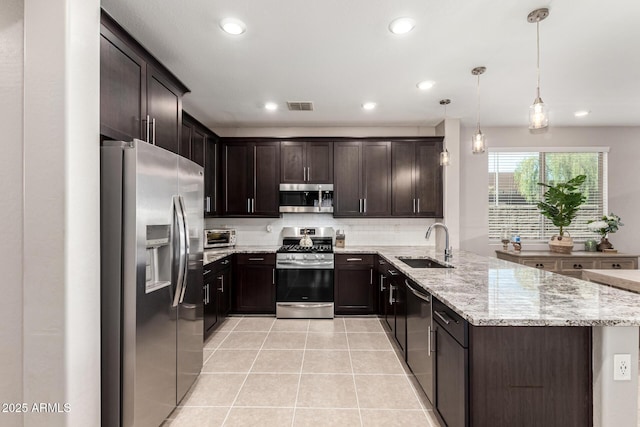 19920 W Monterosa St, Litchfield Park, AZ 85340 - kitchen featuring stainless steel appliances, a sink, visible vents, dark brown cabinets, and hanging light fixtures