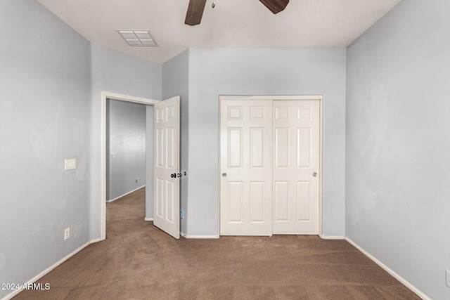 unfurnished bedroom featuring carpet flooring, ceiling fan, and a closet