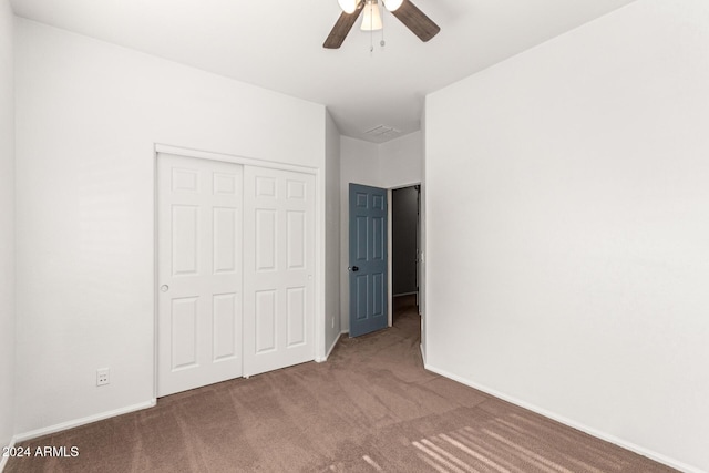 unfurnished bedroom featuring ceiling fan, a closet, and carpet