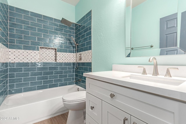 full bathroom featuring tiled shower / bath combo, toilet, wood-type flooring, and vanity