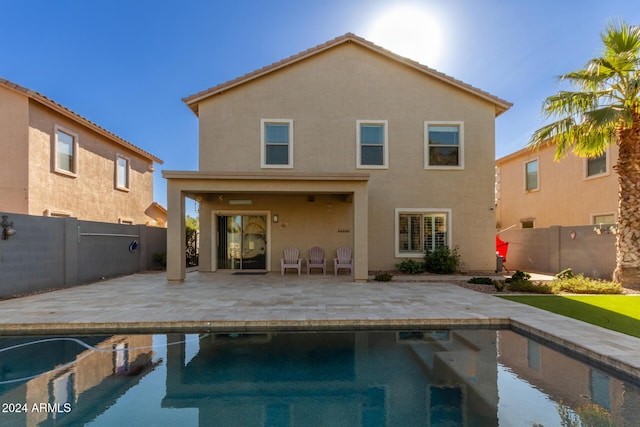 rear view of house with a patio and a fenced in pool