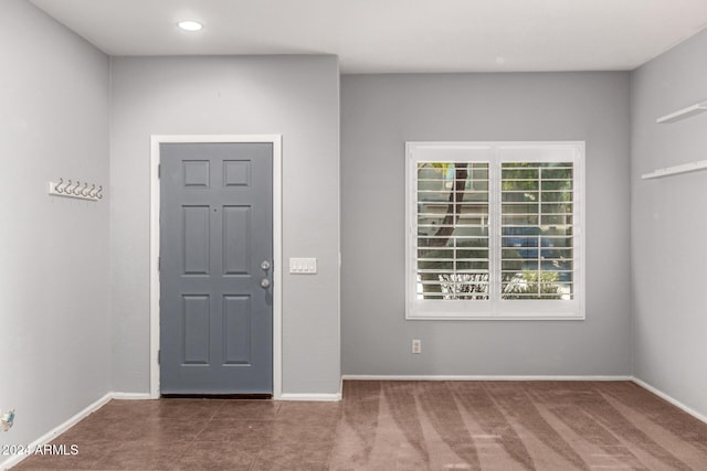 entryway featuring dark carpet