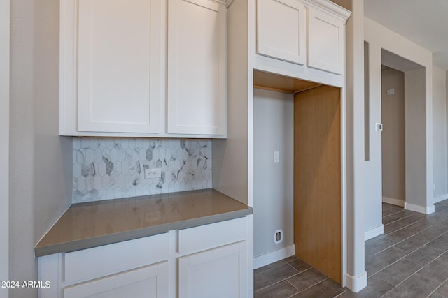 kitchen with tasteful backsplash and white cabinetry