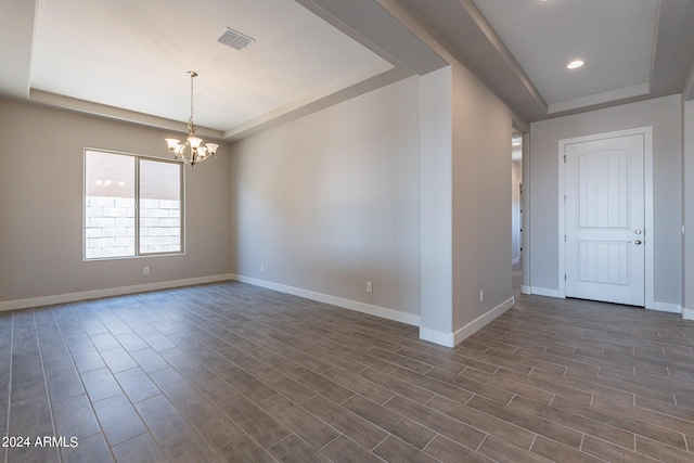 unfurnished room featuring a tray ceiling and dark wood-type flooring