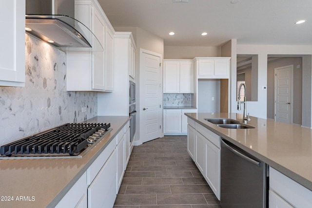 kitchen featuring white cabinetry, appliances with stainless steel finishes, wall chimney exhaust hood, backsplash, and sink