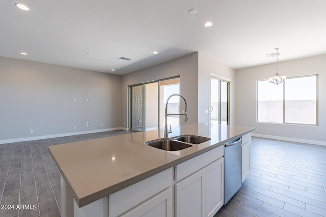 kitchen featuring a center island with sink, stainless steel dishwasher, white cabinets, decorative light fixtures, and sink