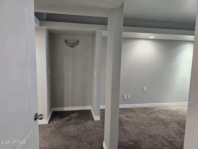 basement with carpet, baseboards, and a textured wall