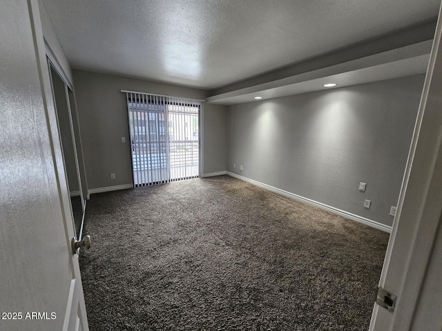 empty room featuring baseboards, a textured ceiling, and carpet