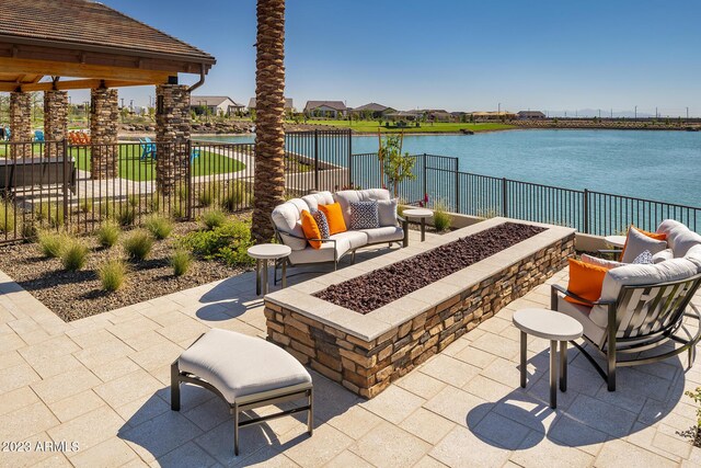 view of patio featuring a water view and an outdoor living space with a fire pit