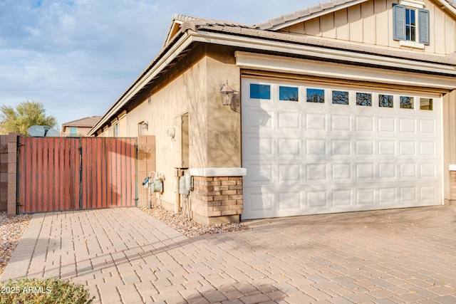 20742 E Mockingbird Dr, Queen Creek, AZ 85142 - view of home's exterior with a gate, fence, stucco siding, board and batten siding, and decorative driveway