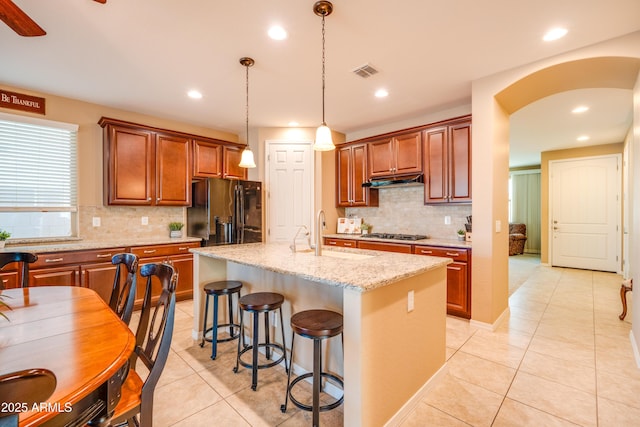20742 E Mockingbird Dr, Queen Creek, AZ 85142 - kitchen with black refrigerator with ice dispenser, a sink, light tile patterned flooring, arched walkways, and visible vents