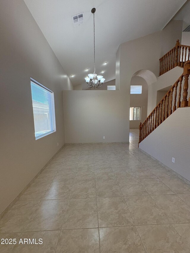 33512 N 24th Ln, Phoenix, AZ 85085 - empty room with healthy amount of natural light, stairs, arched walkways, high vaulted ceiling, and a chandelier