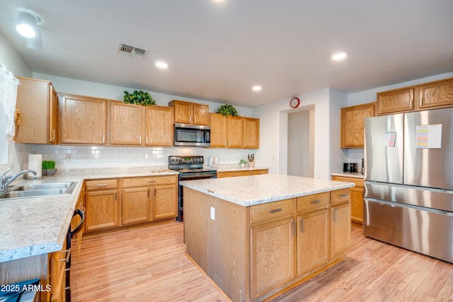 kitchen featuring black appliances, a center island, sink, backsplash, and light hardwood / wood-style flooring