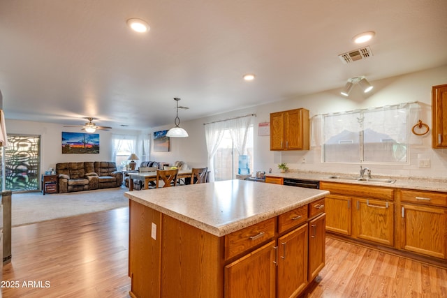 kitchen with dishwasher, sink, backsplash, light wood-type flooring, and a kitchen island