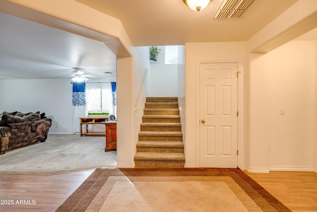 stairway featuring hardwood / wood-style flooring and ceiling fan