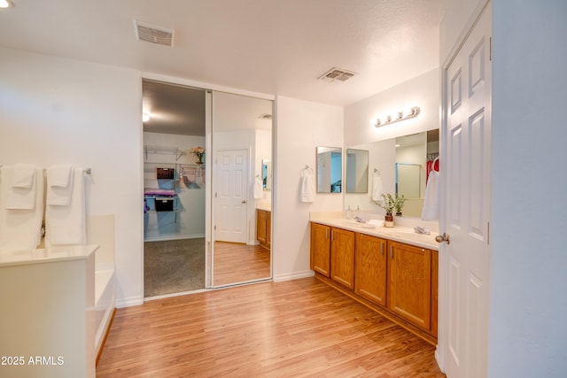 bathroom with vanity, hardwood / wood-style flooring, and a bathtub