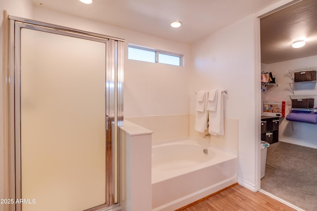 bathroom with plus walk in shower and hardwood / wood-style flooring