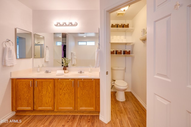 bathroom with wood-type flooring, toilet, and vanity