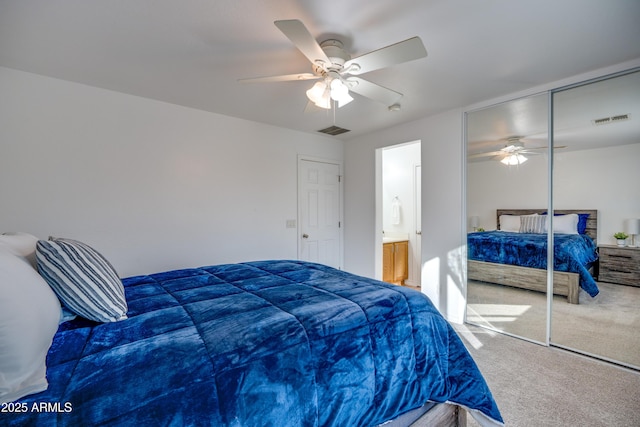 carpeted bedroom featuring ceiling fan, ensuite bathroom, and a closet