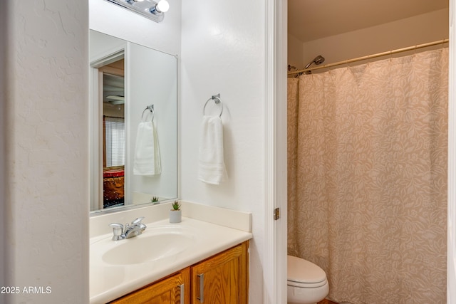 bathroom with toilet, walk in shower, and vanity