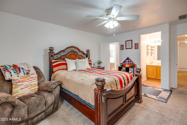 carpeted bedroom with ceiling fan and ensuite bathroom