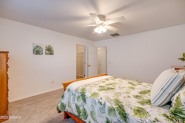 bedroom featuring a closet, ceiling fan, light colored carpet, and a spacious closet