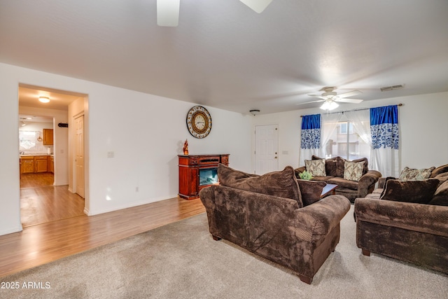 carpeted living room with ceiling fan